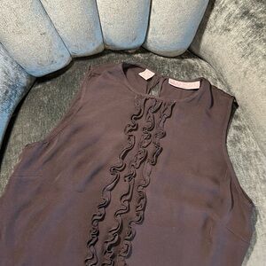 Elegant black silk tank top with ruffle embellishment.